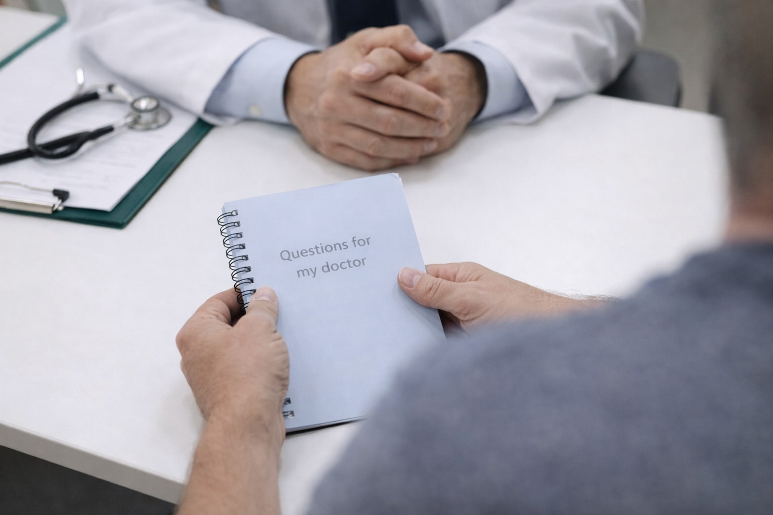 Tampak atas tangan pasien memegang buku catatan berisi daftar pertanyaan saat berdiskusi dengan dokter orthopaedi tanpa menampilkan wajah